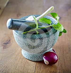 Stone pestle and mortar with mint and garlic