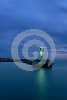Stone pier in Darlowo in the evening. Lights on the beach. Traffic lights in the port. Blue hour. Poland