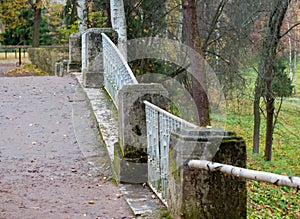 Stone pillars and a metal fence on the bridge in the park