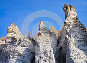 Stone pillars on the rocky shores of the Siberian taiga river in autumn