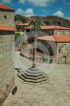 Stone pillory in square encircled by gothic houses