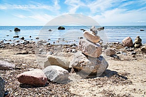 Stone pyramid on the Baltic Sea overlooking with blue sky and sunshine. Spiritual