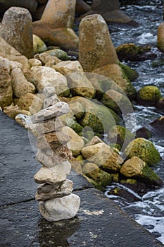 Stone pyramid on the beach. Pile of rocks on a mole.