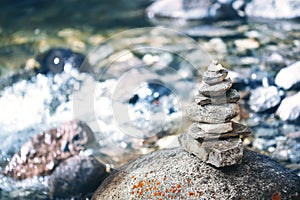 Stone pyramid cairn near river, buddhism