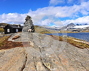 Stone pyramid in mountains at the lake