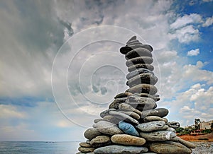 Stone pyramid on sea stone coast near to kite sand beach on tropical island. Greece islands Bahamas holidays vacation sightseeing