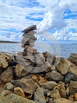 Stone Pyramid on The Seashore with Beautiful Cloudy Sky in the Background