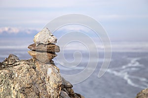 Stone pyramids for spirits on Olhon island. Baikal lake winter landscape