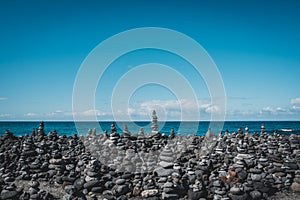 Stone pyramids, stacked stones at beach with ocean background