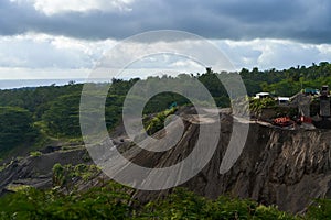 A stone quarry in Indonesia. Large equipment such as bulldozers and dump trucks are working on the site photo