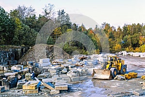 Stone quarry with limestone and a Wheel loader at autumn