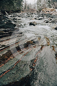 Stone relief of a mountain river. flow of a mountain river on a cloudy cold weather. Austria, Hohe Tauern .Spring