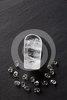 Stone rhinestone. Natural transparent stones lie on a black modern background. Spa, yoga, cover. Copy space for your text. Flat