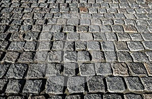 Stone road close up. Old pavement of granite. Grey cobblestone sidewalk. Mock up or vintage grunge texture.