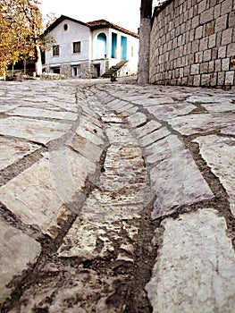 Stone road and an old house in Petrela, Albania.