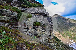 stone rock with colored moss against the background of Baikal green mountains in siberia