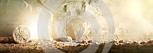 Stone is rolled away from empty grave on Easter morning. Jesus Christ resurrection. Empty tomb of Jesus with light. Born