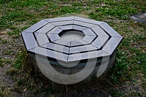 stone round fountain with a protective grid of twisted prisms.