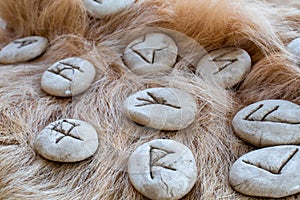 Stone runes on a animal fur. Futhark viking alphabet. Close up photo of Norse runes