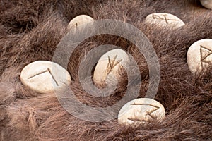 Stone runes on a animal fur. Futhark viking alphabet. Close up photo of Norse runes