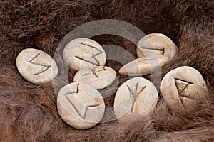 Stone runes on a animal fur. Futhark viking alphabet. Close up photo of Norse runes