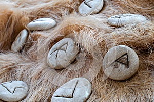 Stone runes on a animal fur. Futhark viking alphabet. Close up photo of Norse runes