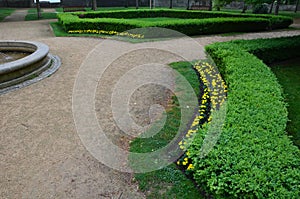 Stone sandstone circular fountain in the park. built of sandstone filled with water. lined with a light threshing gravel road with
