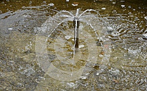 Stone sandstone round fountain in the park. built of sandstone filled with water. lined with a light threshing gravel path with th