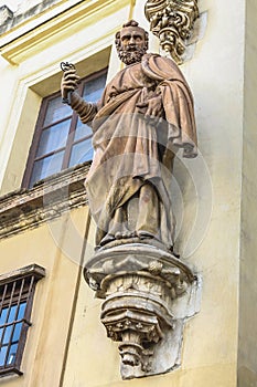 Stone sculpture of the Apostle Saint Peter on the entrance facade of a Christian temple,