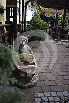 Stone sculpture of a boy carrying a cart in the courtyard of a residential building