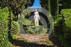 Stone sculpture of a classical woman in a garden