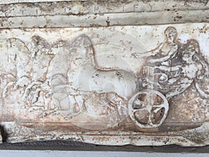 A stone sculpture of horses & chariots