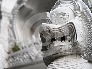 The stone sculpture of a lion gate guardian of the temple