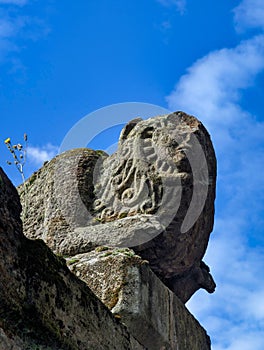 Stone sculpture, a lion with humanized faces that are transfigured into a sun and a moon, San Bartolome de Nava cemetery, Asturias