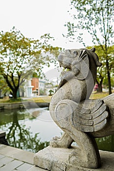 Stone sculpture of myth by pond,China