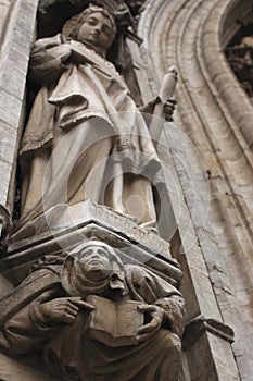 Stone sculptures on ancient catherdal in Europe. Gargoyle face. Catholic architecture. Religious statue.