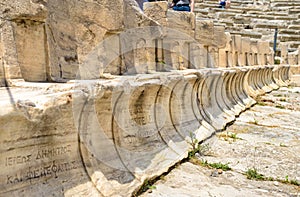 Stone seats of Theater of Dionysus near Acropolis, Athens, Greece. Marble chairs with owners names inscription