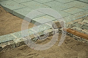 Stone setts blocks being sand-seated in a construction site