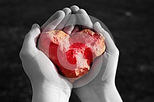 Stone shining red heart in hand