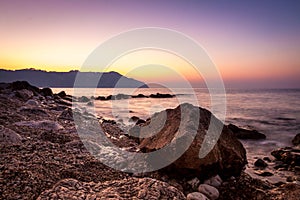 Stone and silky waves at sunset - nature background