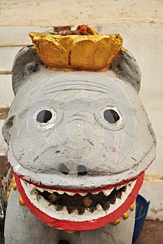 Stone singha statue guardian of Wat Aham or Monastery of the Blossoming Heart and stucco tigers for Laotian people and foreign