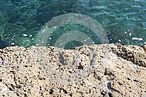 A stone slab near the sea. The texture of the water and stone.