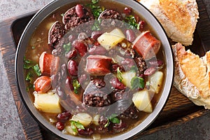 Stone soup of red beans, potatoes, chorizo, black pudding close-up in a bowl. horizontal top view photo