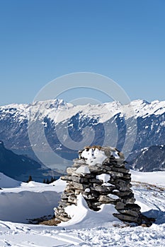 Stone stack in bernes alps with snow caped mountains and brienzersee in background
