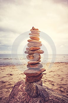 Stone stack pyramid on a beach, zen, harmony and balance concept, color toning applied