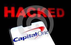 Capital One Bank logo on the smartphone and red alerting word HACKED on the blurred background. Conceptual photo for data breach