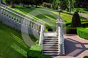 A stone staircase with balustrades railing down into the garden.