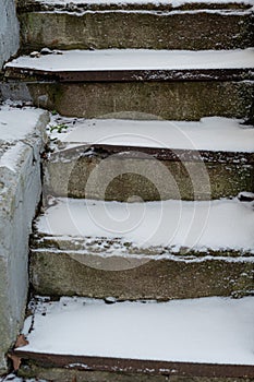 The stone staircase is covered with snow. Concept, winter has come, cautiously slippery.