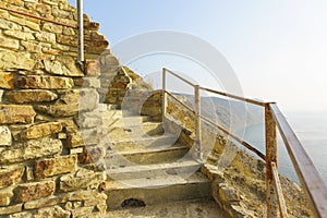 A stone staircase on a steep mountain slope above the sea