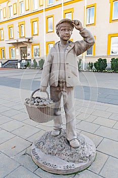 Stone statue of boy with wicker basket full of mushrooms
